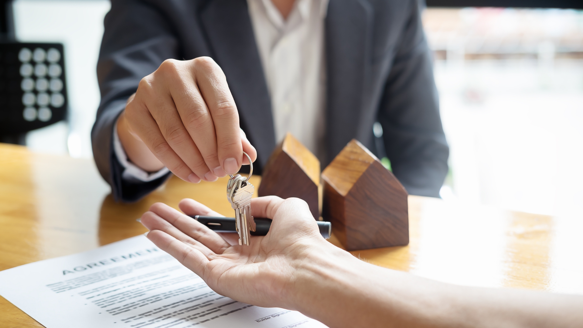 A person handing a house key to another person