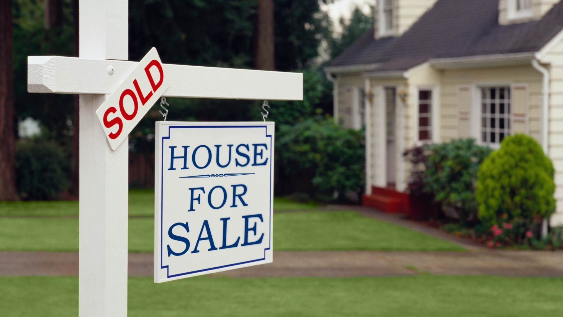 A house for sale sign in front of a house